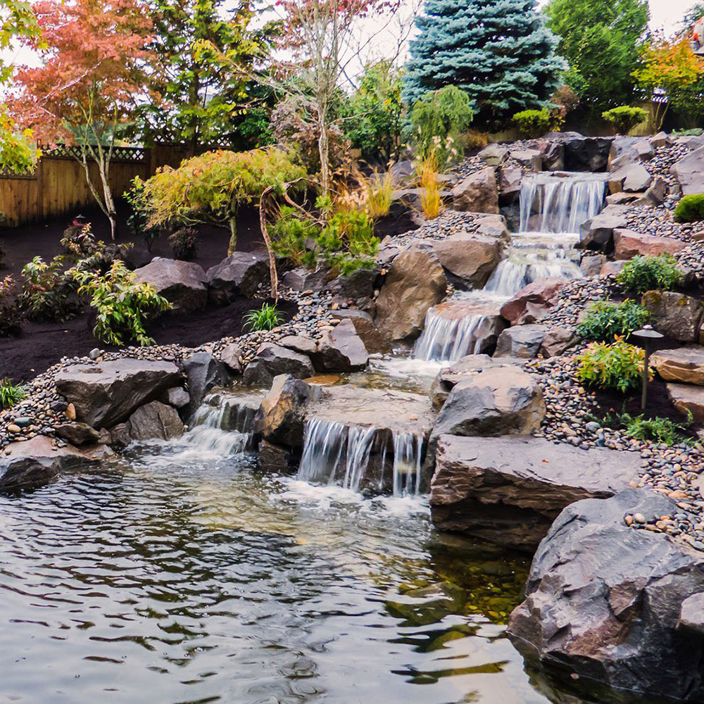 a multi-step waterfall water feature into a pond
